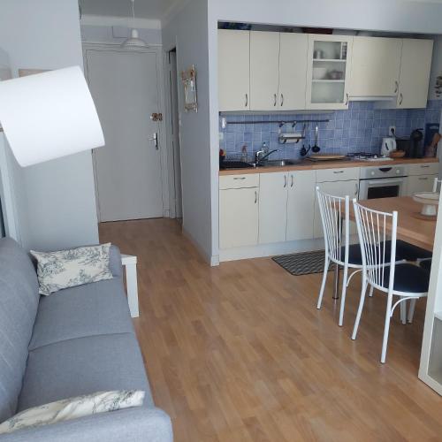a kitchen and living room with a couch and a table at Studio lumineux proche port & plages in Bénodet