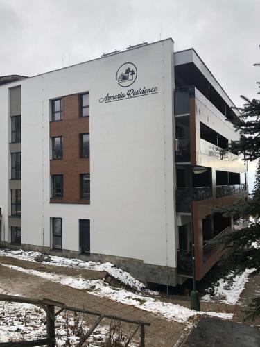 a building with a sign on the side of it at Armeria Residence 32 - Strbske pleso in Štrbské Pleso