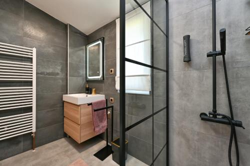 a bathroom with a sink and a shower at Tonka studio apartman in Križevci