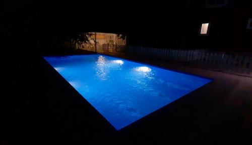 a large blue swimming pool in a dark room at Family holiday home. in Qusar