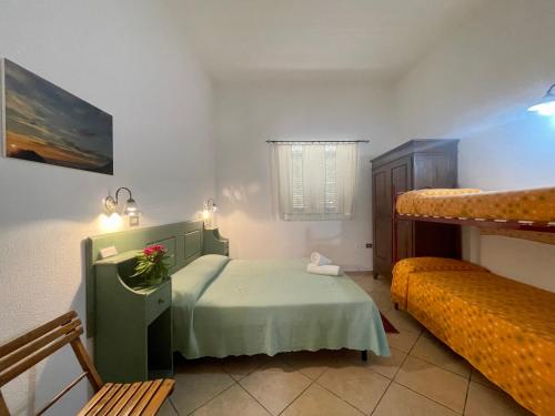 a bedroom with a bed and two bunk beds at Agriturismo Paulesa in Cala Gonone