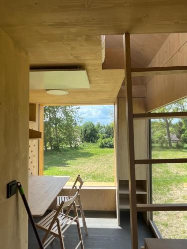 une petite maison avec une grande fenêtre, une table et des chaises dans l'établissement Posedy Panský dvůr Telč, à Telč