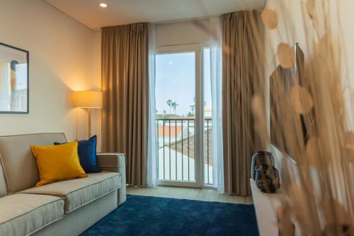 a living room with a couch and a large window at Downtown PDL Premium in Ponta Delgada