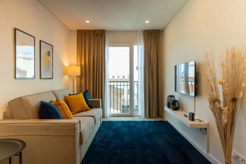 a living room with a couch and a large window at Downtown PDL Premium in Ponta Delgada