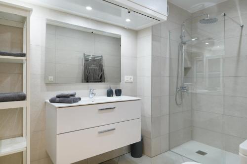 a white bathroom with a sink and a shower at La Luz de la Luna in Costa Teguise