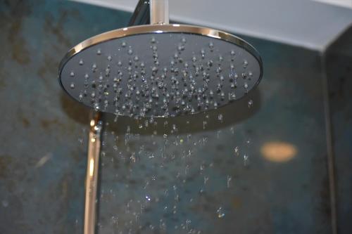 a shower head with water coming out of it at Sun & Sea Apartments Plakias II in Plakias