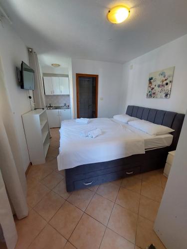 a bedroom with a large bed and a refrigerator at Guest House Nina in Novigrad Istria