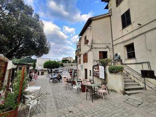 een straat met tafels en stoelen naast een gebouw bij La Casa in Piazza in Toffia