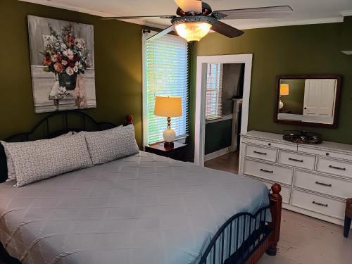 a bedroom with a bed and a dresser and a mirror at Blue Ruby at Grice-Fearing B&B in Elizabeth City