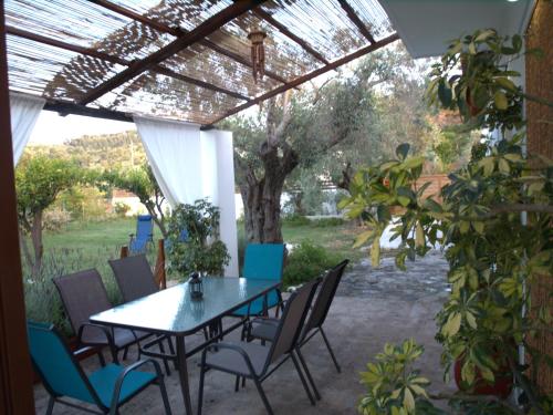 a patio with a table and chairs under a pergola at ilioni house in Skopelos Town