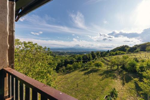 balcón con vistas a un campo y a los árboles en Cosy Hill Home Rucman With a Breathtaking View, en Zgornja Pohanca