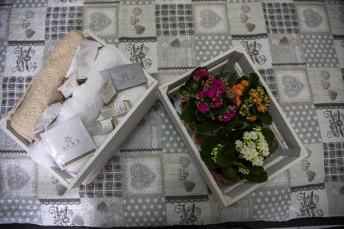 two boxes of flowers and towels on a bed at L'Alpino in Sulmona