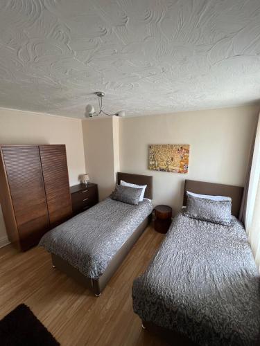 a bedroom with two beds and a ceiling at Stay in Yeovil Town Centre, Large 2 BD Apt With Parking, Sleeps 4 in Yeovil