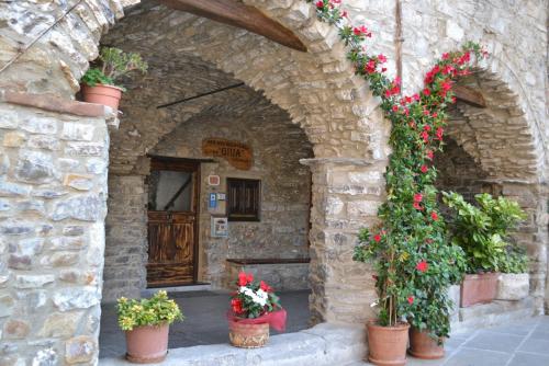 an entrance to a stone building with flowers in pots at B&B Da Giua' in Apricale