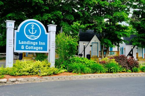 a sign for a lighthouse inn and gardens in front of a house at The Landings Inn and Cottages at Old Orchard Beach in Old Orchard Beach