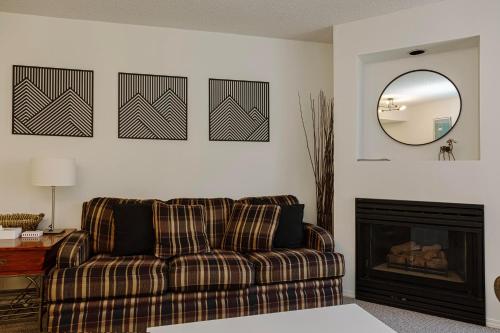 een woonkamer met een bank en een spiegel bij 1 bed family friendly condo on quiet Blackcomb - sleeps 5 in Whistler