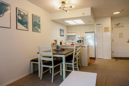 een keuken met een tafel en stoelen en een koelkast bij 1 bed family friendly condo on quiet Blackcomb - sleeps 5 in Whistler