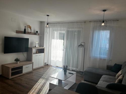 a living room with a couch and a tv at Apartman Mila in Biograd na Moru