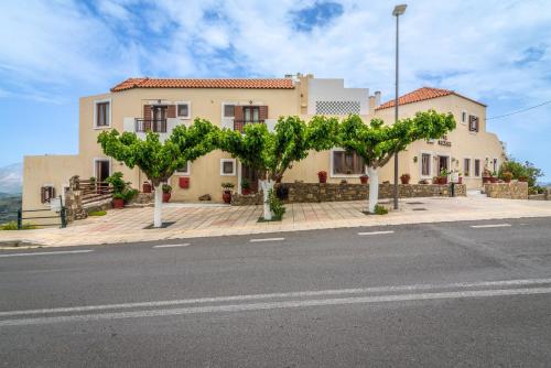 a house with trees in front of a street at Hotel Marina in Anogia