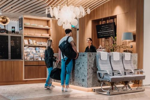 three people standing at the counter of a salon at zumOXN in Laufen