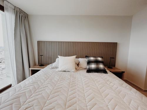 a large white bed with two pillows on it at Aunaisin - Amundsen I in Ushuaia