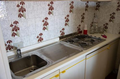 a kitchen with a sink and a stove at Alloggio incantevole con piscina in Ricadi
