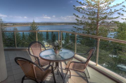 a table and chairs on a balcony with a view of a lake at Northpoint Apartments in Port Macquarie