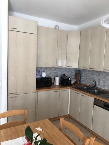 a kitchen with white cabinets and a wooden table at Casa Marisa in Ponsacco