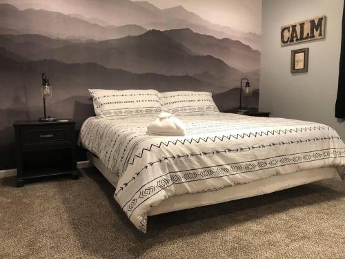 ein Schlafzimmer mit einem Bett mit einem Wandbild der Berge in der Unterkunft 1 mi to Dollywood mins to all attractions & GSMNP in Sevierville