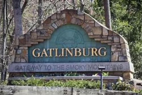 a sign for the grizzlingling entrance to the snoqualifysenalsenal at 1 mi to Dollywood mins to all attractions & GSMNP in Sevierville