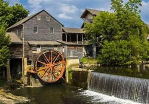 a watermill in front of a house with a waterfall at 1 mi to Dollywood mins to all attractions & GSMNP in Sevierville