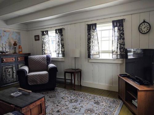 Dory Buff House في Princeton: غرفة معيشة فيها كرسي وتلفزيون