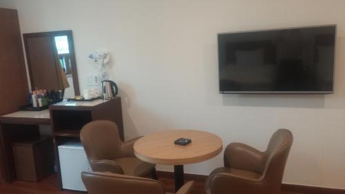 a room with a table and chairs and a television on the wall at Youngbin Hotel in Seoul