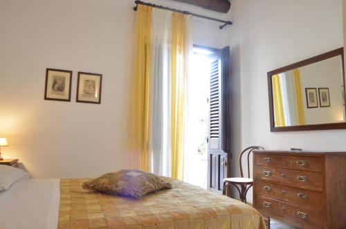 a bedroom with a bed and a dresser and a window at GIARDINO del MARE in Petrosino