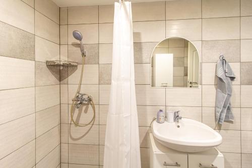 a bathroom with a shower curtain and a sink at Déli Terasz A Apartman Free parking, self-check-in anytime in Győr