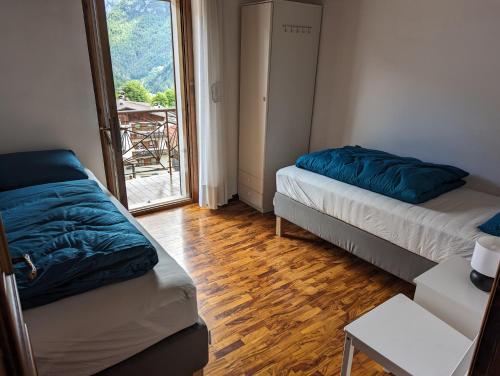 a small room with two beds and a window at Appartement Il Gallo in Forno di Zoldo