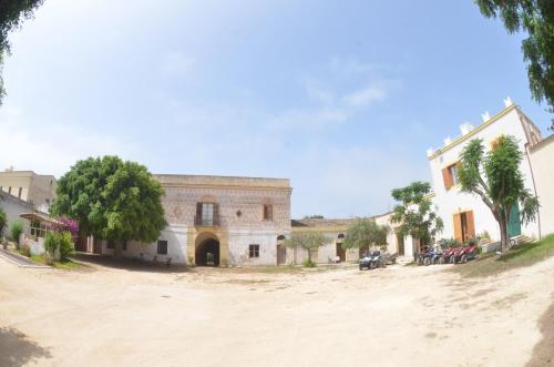 a building on a dirt road next to a street at GIARDINO del MARE in Petrosino
