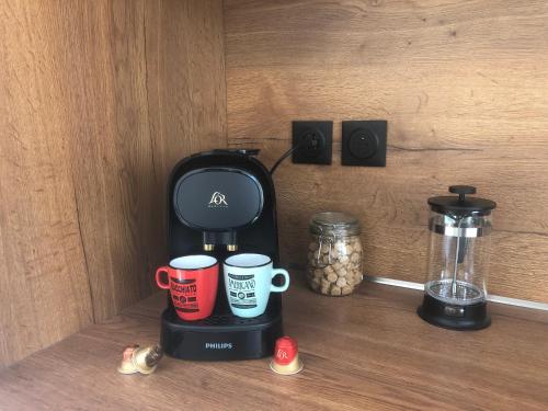 a coffee maker with two coffee cups on a shelf at * Maison de Ville en Pleine Nature * in Marseille