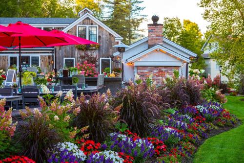 a garden with flowers in front of a house at The Barnstead Inn in Manchester Center