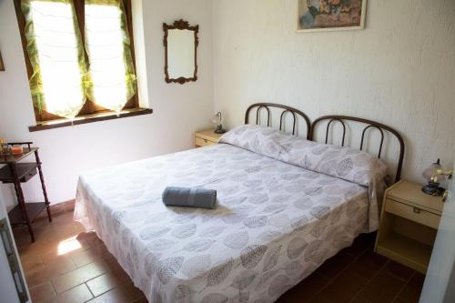a bedroom with a bed with a white comforter at Alloggio incantevole con piscina in Ricadi