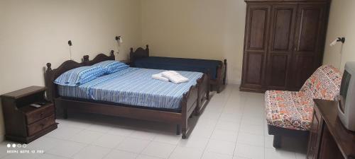 1 dormitorio con 1 cama, vestidor y silla en alloggio greenpark, en Milazzo