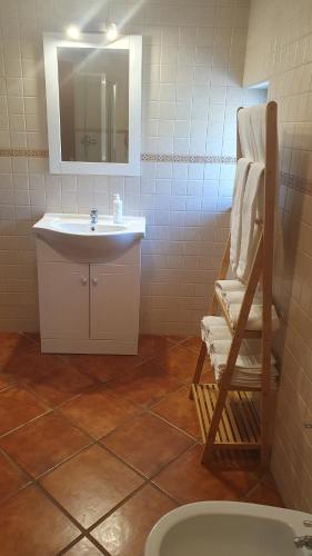 W łazience znajduje się umywalka, lustro i krzesło. w obiekcie Quinta da Figueirinha w mieście Marvão