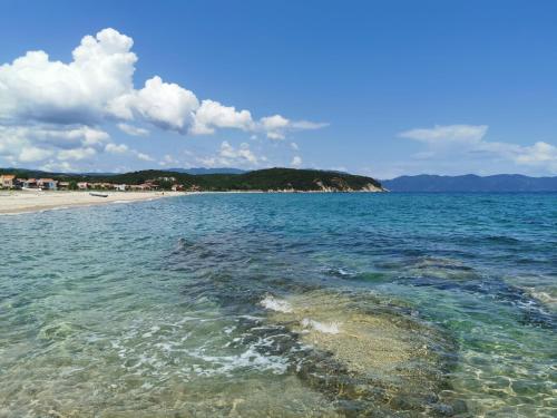 a body of water with a beach in the background at Villa Calypso Ierissos in Ierissos