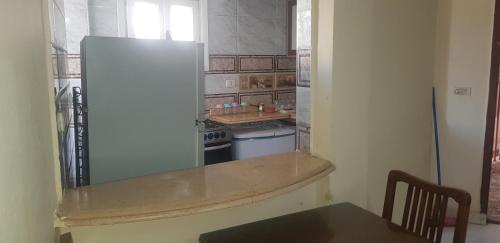 kuchnia z białą lodówką i stołem w obiekcie Davinche Al Mamoera w Aleksandrii