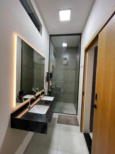 uma casa de banho com 2 lavatórios e um chuveiro em Cantinho Estrelado - Casa automatizada com ALEXA em Brotas