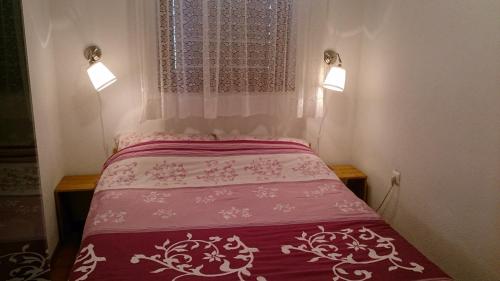 sypialnia z łóżkiem z czerwoną i białą narzutą w obiekcie Bakina kućica - Grandma's cottage w mieście Gospić