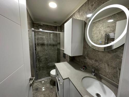 a bathroom with a sink and a mirror and a shower at Rose Plus Residence in Istanbul