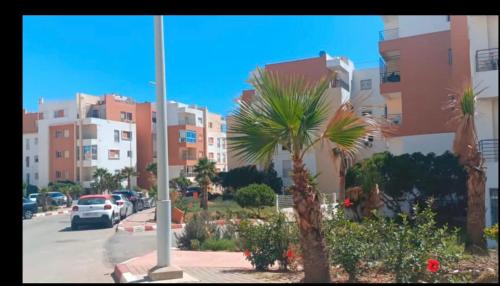 vista su un parcheggio con palme e edifici di Appartement 2 chambres résidence Sables d’or Tanger a Tangeri