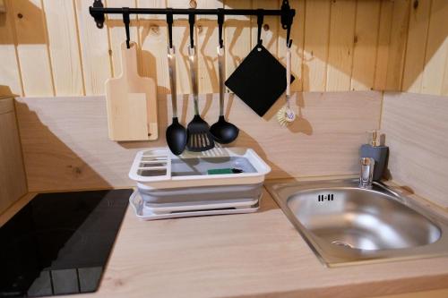 a kitchen counter with a sink and utensils at Wooden house Ažbe in Bled