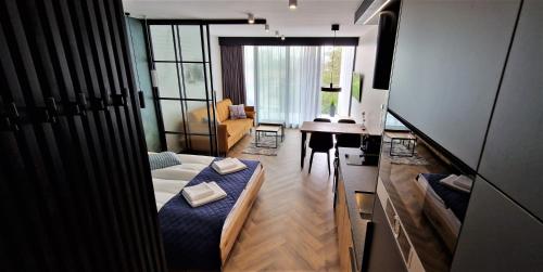 a living room with a bed and a desk in it at Lake View Mielno in Mielno